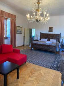 巴尼奥阿里波利Villa Il Padule的客厅配有床和红色沙发