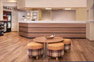 林夕昆高地巴尔的摩BWI机场居住馆酒店的大堂设有一张桌子和两张凳子