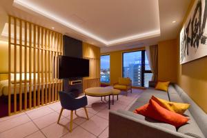 出云市The Centurion Hotel & Spa Classic Izumo的带沙发和电视的客厅