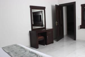 哈费尔巴廷Rayat Alshalal Hotel 2的一间卧室配有电视和带镜子的梳妆台