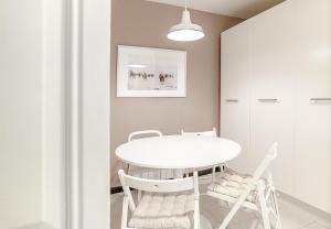 希洪Piso catalogado en el centro de Gijon的白色的用餐室配有白色的桌椅