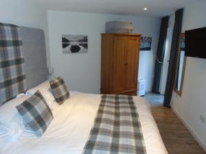 格拉斯哥Dreamwood Cottage, Loch Lomond, Luxury Apartment.的一间卧室配有一张带枕头的床。