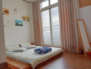 嘉义市拉瓦宅 輕旅店 - Lawa House的一张位于带大窗户的房间内的床铺