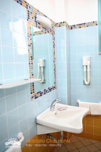 马洛塔马洛塔阿芭佳俱乐部酒店的蓝色瓷砖浴室设有水槽和镜子