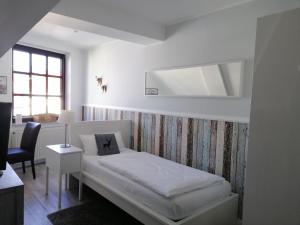 克桑滕努梅尔酒店的白色的客房配有一张床和椅子
