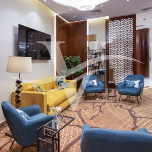 沙迦Viola Hotel Apartments的客厅配有黄色沙发和蓝色椅子