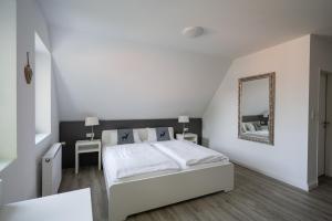 克桑滕努梅尔酒店的白色卧室配有床和镜子