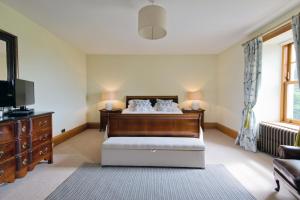 LybsterAlbion House- Highlands的一间卧室配有一张床、一台电视和一张沙发