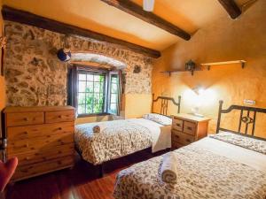 赫罗纳Masia with pool and beautiful views near Girona的一间卧室设有两张床和石墙