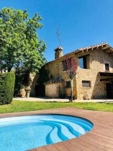 赫罗纳Masia with pool and beautiful views near Girona的石头房子前面的游泳池