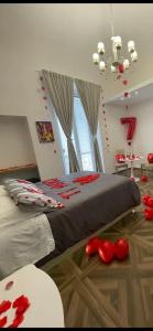 曼弗雷多尼亚Relais del Corso的卧室配有一张大床,地板上装饰有红色