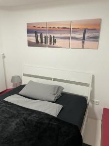汉堡Kastanienallee 7的卧室配有一张墙上三幅画作的床