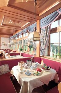 图尔内巴赫-劳维斯维尼尔瓦尔德霍夫丽格酒店的用餐室配有餐桌和食物