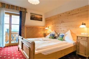 福森贝格费瑞豪斯兰德宫酒店的一间卧室设有一张带木墙的大床