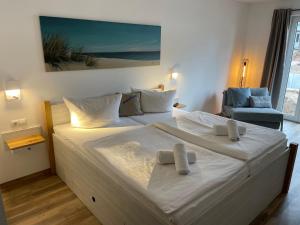 奥斯赛拜-塞林Hotel meerblau的一张大白色的床,位于带椅子的房间