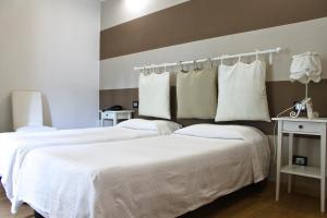 加维艾尔伯格艾尔城堡酒店的配有白色床单的酒店客房内的两张床