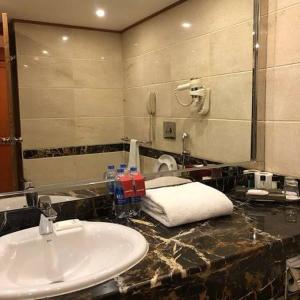 拉合尔Hotel Grand Lahore的一间带水槽和镜子的浴室