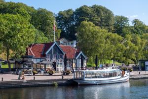 锡尔克堡Villa Søholt - Silkeborg Bed and Breakfast的停靠在河边一座建筑物前面的船只