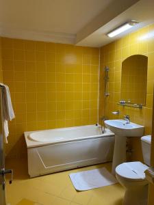 波亚纳布拉索夫Hotel Miraj - Restaurant & Sauna & Biliard的带浴缸、卫生间和盥洗盆的浴室