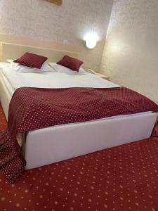 波亚纳布拉索夫Hotel Miraj - Restaurant & Sauna & Biliard的卧室配有一张大床,提供红色床单和枕头