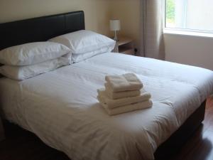 恩尼斯克朗Sun Apartments的一间卧室配有一张床,上面有两条毛巾