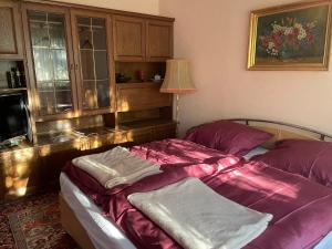 普克斯多夫Suburb Hostel的一间卧室配有一张紫色床单的床