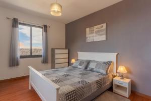 里韦拉布拉瓦Villa Rosa with private pool by HR Madeira的一间卧室配有一张床,享有海滩美景