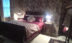 卡林福德休闲度假屋的一间卧室配有一张粉红色花卉壁纸的床