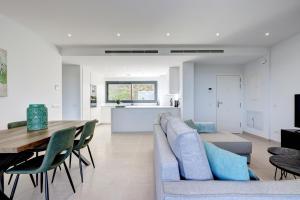 马拉加085 Modern Apartment in Trendy La Cala Golf Resort的客厅以及带沙发和桌子的厨房。