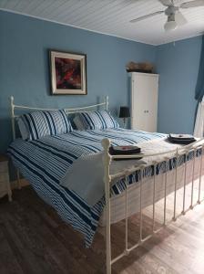 MénéacLe Breil Furet的一间卧室配有一张蓝色墙壁的床