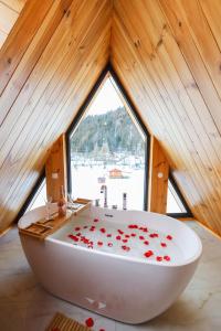托普利察Cozy Cabin A Frame的浴室设有白色浴缸,上面装饰有红色玫瑰花瓣