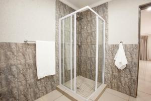 比勒陀利亚Windmills Rest的浴室里设有玻璃门淋浴