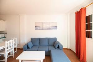 戈梅拉岛圣塞瓦斯蒂安Hotel Apartamentos Villa Gomera的客厅配有蓝色的沙发和桌子