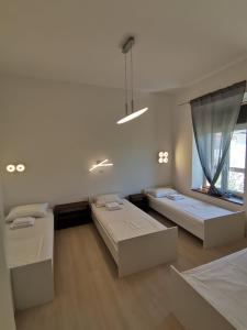 帕格Hostel Jadran的白色的客房设有两张床和窗户。