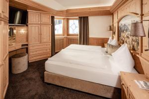 塞尔瓦迪加尔代纳山谷Suites Hotel Garden的卧室配有一张白色大床