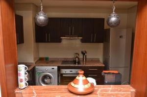 阿加迪尔Lovely Marina Flat的厨房配有炉灶、洗衣机和烘干机