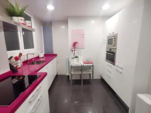 毕尔巴鄂Turquesa :) Parking and Wifi的厨房配有白色橱柜和紫色台面