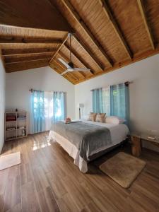 欧丘里欧Ecoscape Jamaica - Cottages by the river的一间卧室设有一张大床和木制天花板。