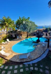 伊利亚贝拉Monalisa Guesthouse Pé na Areia Ilhabela的棕榈树度假村内的游泳池