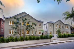 悉尼Mulwarree Avenue Apartments by Urban Rest的一座大型白色房子,前面有棕榈树