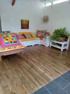 TeavaroMoorea Chill House And Beach的带沙发和木地板的客厅