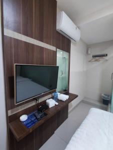 巴淡岛中心Hotel Morena Batam的配有电视、床和镜子的客房