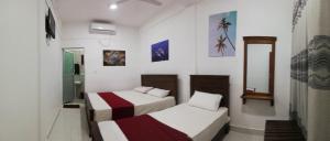 乌普韦利Dive beach palace的白色墙壁客房的两张床