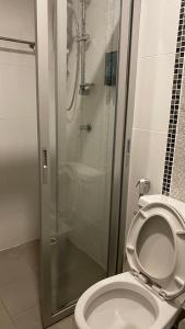 巴吞他尼Hotel IYA的一间带卫生间和玻璃淋浴间的浴室