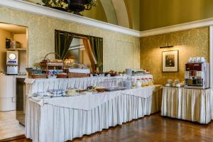 的里雅斯特阿尔伯格亚拉珀斯塔酒店的自助餐,配有白色桌子和食物