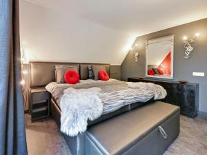 DidamTasteful Villa in Didam with Garden的一间卧室配有一张大床、红色枕头和镜子
