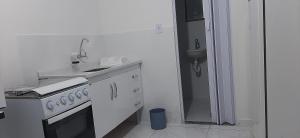 大伊瓜巴LOFT的白色的厨房配有炉灶和水槽