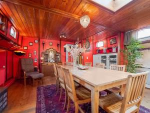 KerkdrielLuxury boat in Kerkdriel的一间拥有红色墙壁和木桌及椅子的用餐室