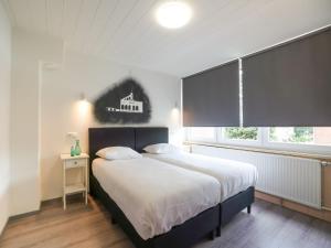 凯尔克拉Terraced house in Kerkrade with a garden的一间卧室设有一张大床和一个窗户。