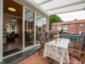 凯尔克拉Terraced house in Kerkrade with a garden的庭院中设有温室,配有桌椅